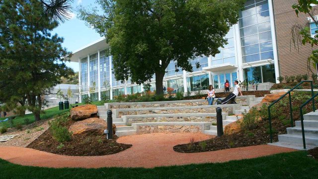 students relaxing in the outdoor space in front of Dwire Hall