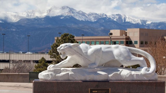 Clyde statue in El Pomar Plaza with snow capped mountains in the background
