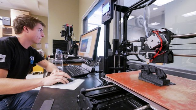 student working with a 3D printer