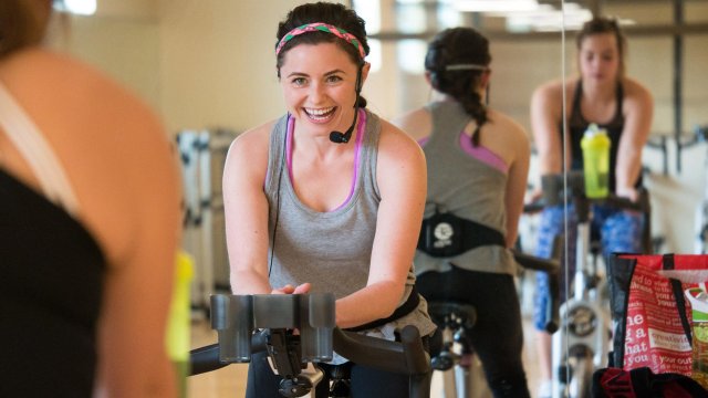 student leading a group indoor cycling class