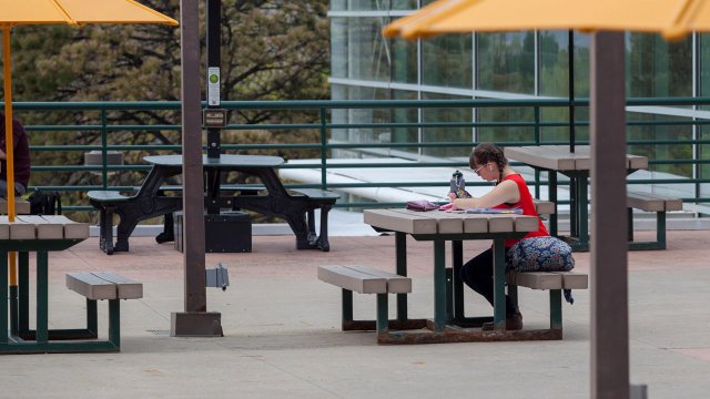 a student studying outside on the Upper Plaza