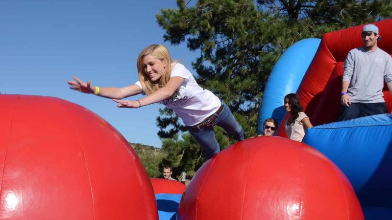 student jumping through a giant inflatable obstacle course