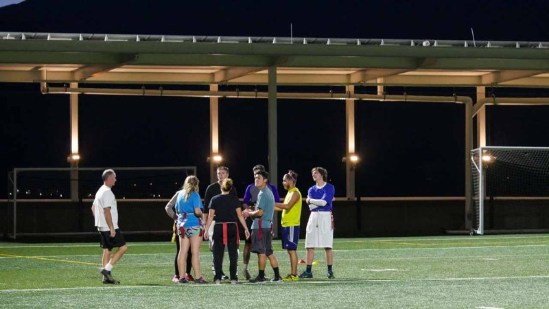 flag football club meeting on Alpine Field for a night game