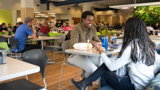 students smiling and enjoying a meal at Cafe 65